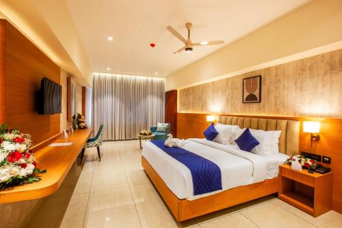 Grand Royal Residency في Pala: غرفة فندق بها سرير ومكتب