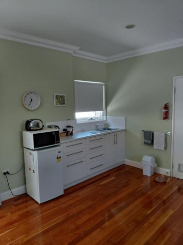 a kitchen with a white refrigerator and a sink at Northwood Bed and Breakfast in Perth