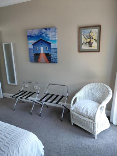 a bedroom with two chairs and a bed and a painting at Northwood Bed and Breakfast in Perth