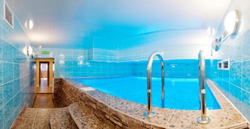 baño con piscina de azulejos azules en Hotel Rent, en Najodka