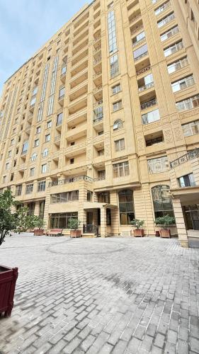 duży budynek z kamiennym dziedzińcem przed nim w obiekcie Sapphire apart w mieście Baku