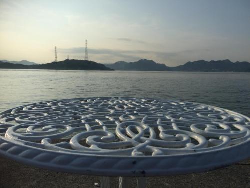 a large metal sculpture next to the water at Guest House & Cafe Ohana in Imabari