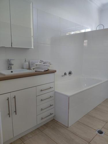 a white bathroom with a sink and a mirror at Northwood Bed and Breakfast in Perth