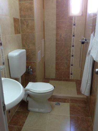 a bathroom with a toilet and a sink and a shower at Guest House SNG in Nesebar