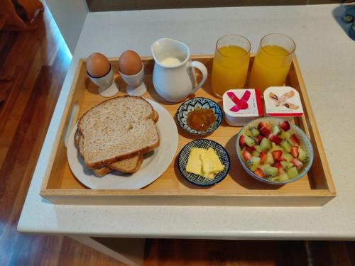 a tray of food with a sandwich and eggs and fruit at Northwood Bed and Breakfast in Perth