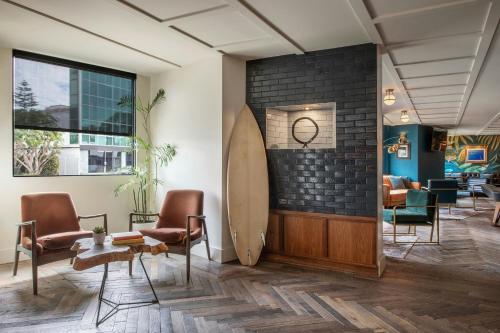 a waiting room with chairs and a surfboard on the wall at FOUND Hotels, Santa Monica, Series by Marriott in Los Angeles