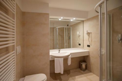 a bathroom with a sink and a toilet and a shower at AlbaResidence Masera26 in Alba