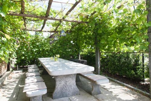 a stone picnic table and benches in a garden at Hotel Gasthof Post AG in Bözen