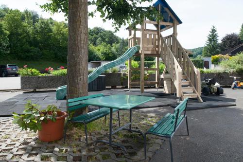 a table and chairs next to a tree with a slide at Hotel Gasthof Post AG in Bözen