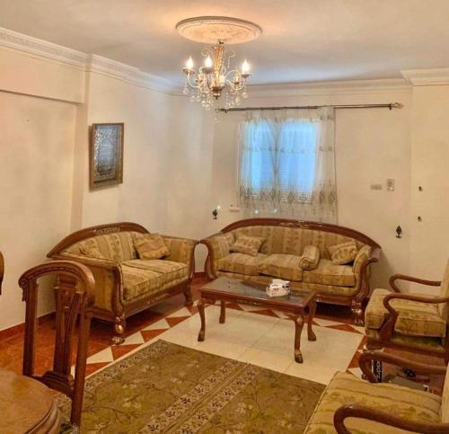 a living room with two couches and a table at Roma apartment in Dumyāţ al Jadīdah
