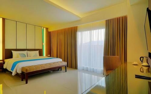 a bedroom with a bed and a large window at Java Lotus Hotel Jember in Jember