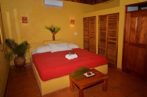 sypialnia z łóżkiem z czerwonym kocem w obiekcie Esencia Hotel and Villas w mieście Playa Santa Teresa