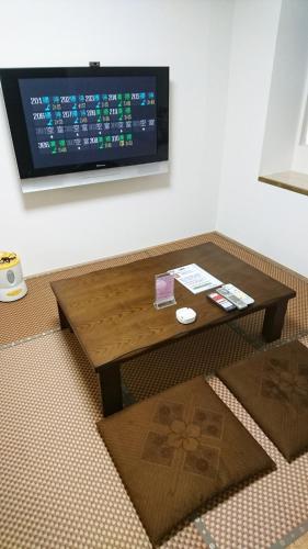 a coffee table in a room with a tv on the wall at Sea Queen Kainan in Kainan