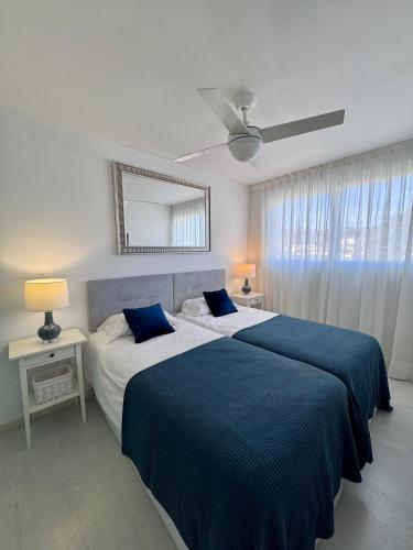 a bedroom with two beds with blue and white sheets at Apartment front line in Moraira