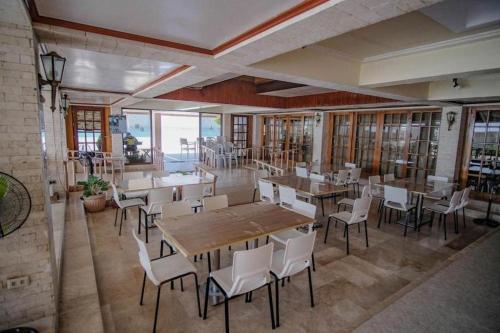 a restaurant with wooden tables and chairs and windows at Santa Fe Beach Club in Ocoy