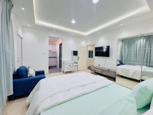 a bedroom with a large bed and a blue couch at Fully Furnished Studio Near Exibition Center Abu Dhabi in Abu Dhabi