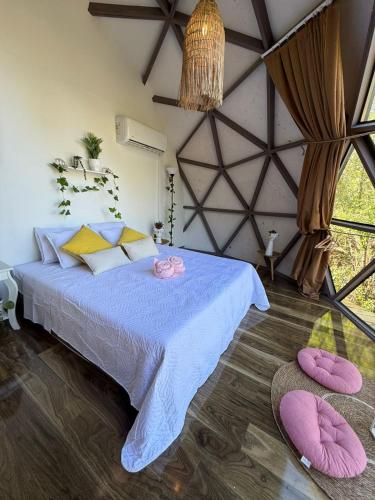 a bedroom with a bed with purple sheets and pink pillows at Domos munaQ Dusty in San Javier