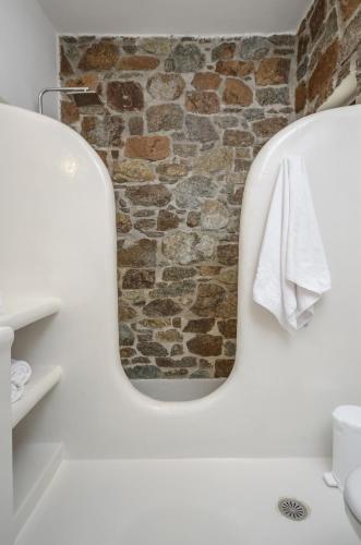 a bathroom with a mirror and a stone wall at Casa Borealis in Naxos Chora