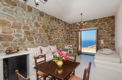 a living room with a table and a stone wall at Casa Borealis in Naxos Chora