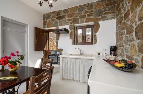 a kitchen with a stone wall and a counter top at Casa Borealis in Naxos Chora