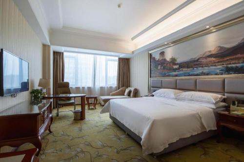 Vienna International Shanghai Nanxiang في Chenjiahang: غرفة فندقية مع سرير كبير وتلفزيون
