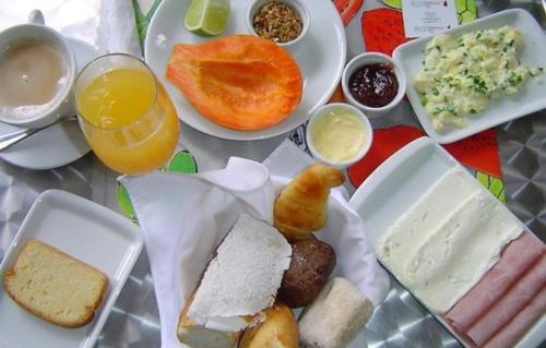 ein Tisch mit einer Reihe von verschiedenen Arten von Lebensmitteln in der Unterkunft Pousada Mirante in Conceição da Barra