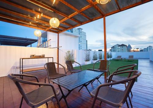 a patio with a table and chairs on a deck at Downtown Oasis 芭提雅市中心独栋泳池别墅 B 5卧6卫 KTV BBQ 芭提雅海滩步行街500m in Pattaya