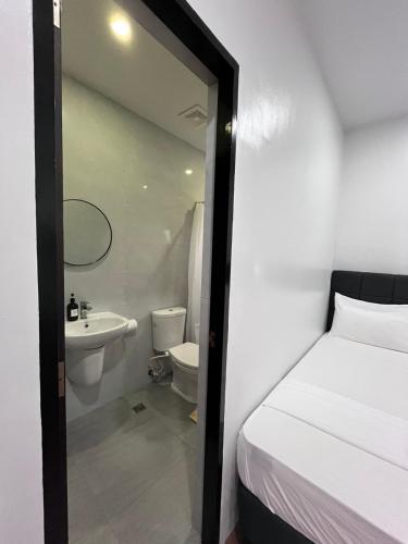 a bathroom with a bed and a sink and a toilet at 20 Boeing Apt in Manila