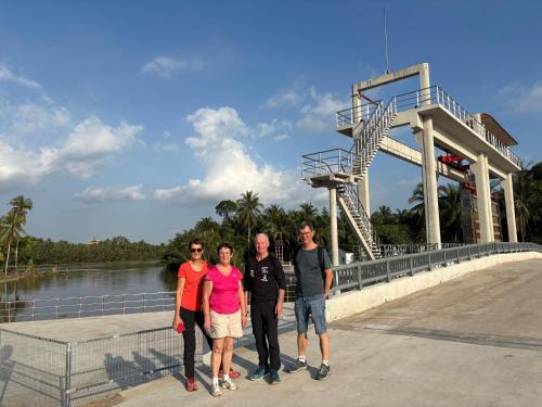 a group of people standing in front of a roller coaster at Homestay Bentre Coco Lodge in Ben Tre