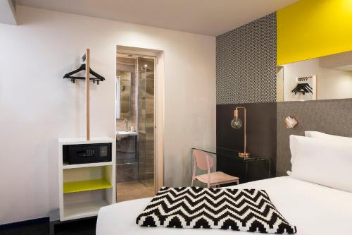a hotel room with a bed and a bathroom at Hotel Duette Paris in Paris