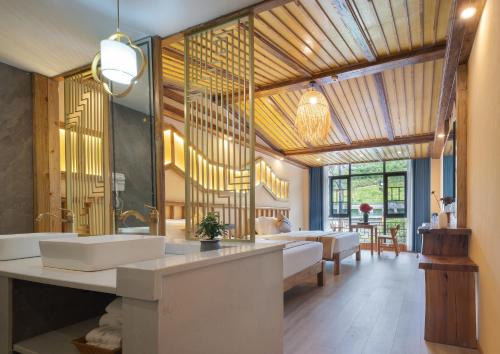 a bathroom with a sink and a living room at Zhangjiajie Oxygen Lodge in Zhangjiajie