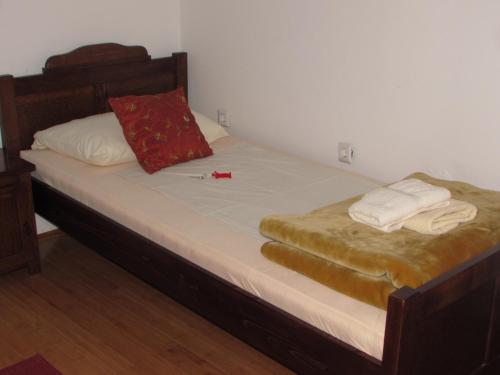 a bed with two towels and a red pillow on it at Smještaj Slavonija in Daruvar