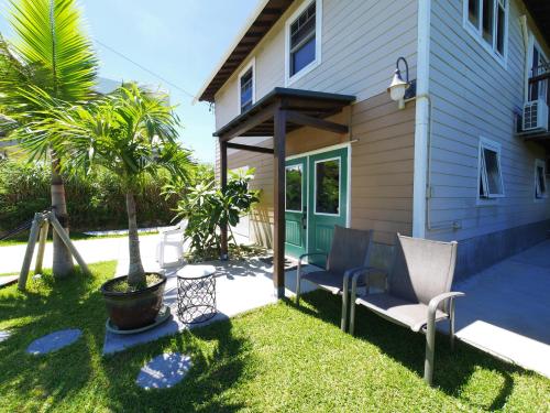 a yard with two chairs and a house at Private Vacation Villa Kohola in Motobu