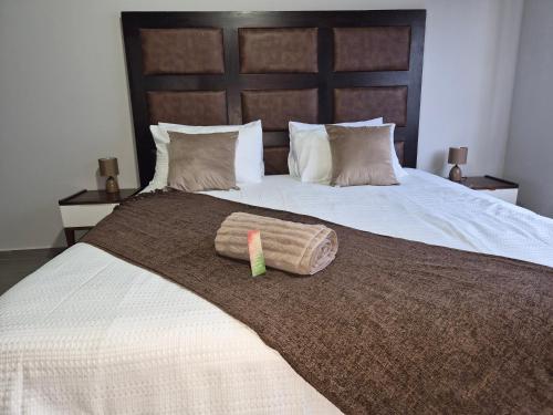 a bed with two pillows and a cup on it at Coastal Cove in Cape Town