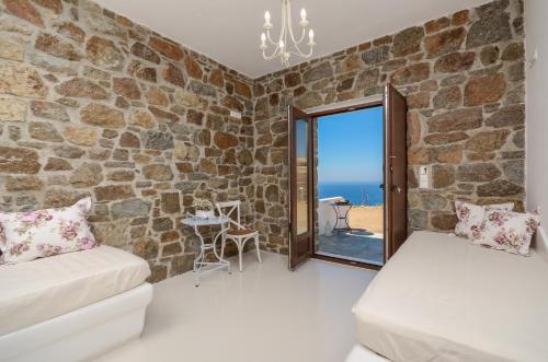 un soggiorno con divano e parete in pietra di Casa Borealis a Naxos Chora