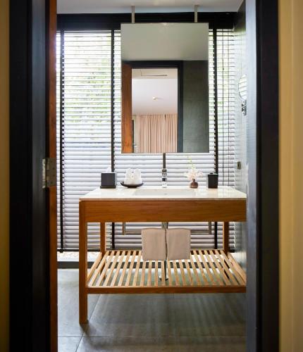 a bathroom with a sink and a mirror at U Inchantree Kanchanaburi in Kanchanaburi