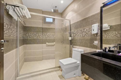 a bathroom with a shower and a toilet and a sink at Grand Residence in Riyadh