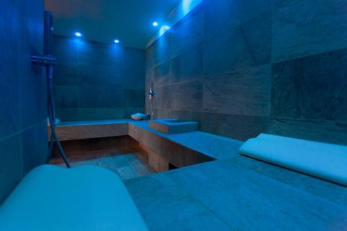 a bathroom with a tub and a shower with blue lights at Hotel Mamiani & Relaxing Spa Urbino in Urbino