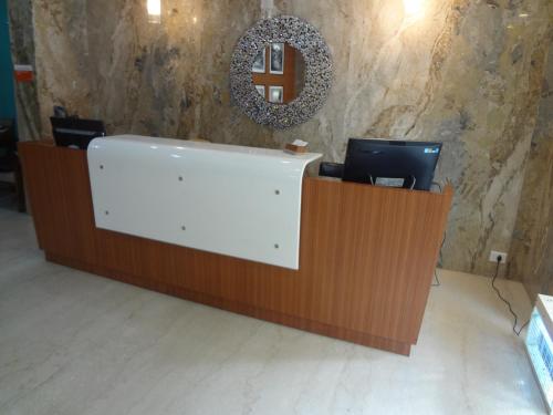 a reception desk with a computer on top of it at Royal Park Hotel Dockyard in Mumbai