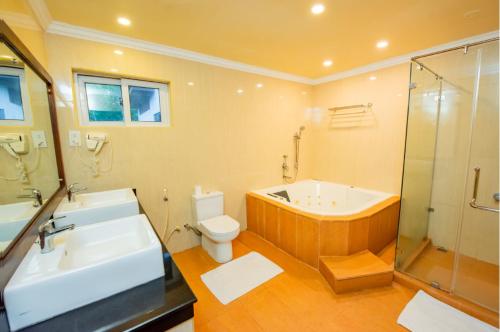 a bathroom with a tub and a toilet and a sink at Peacock Beach Resort- Hambantota in Hambantota