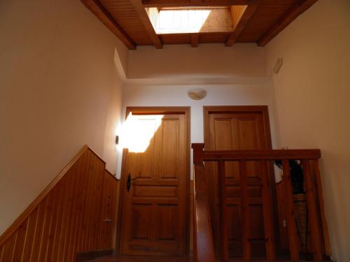 a hallway with two wooden doors and a skylight at Mirasierra II Y III in Navarredonda de Gredos