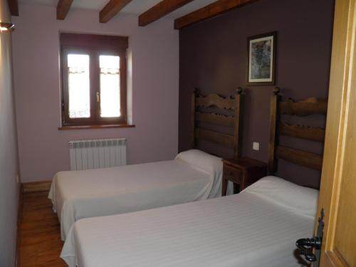 a bedroom with two beds and a window at Mirasierra II Y III in Navarredonda de Gredos