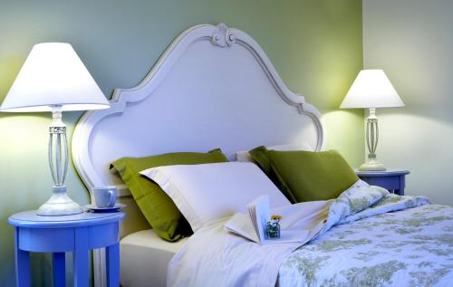a bed with two lamps and a book on it at Avra Private Suites in Lassi