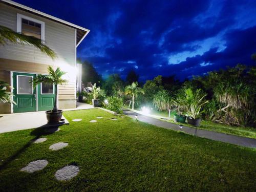 a backyard at night with a grass yard at Private Vacation Villa Kohola in Motobu
