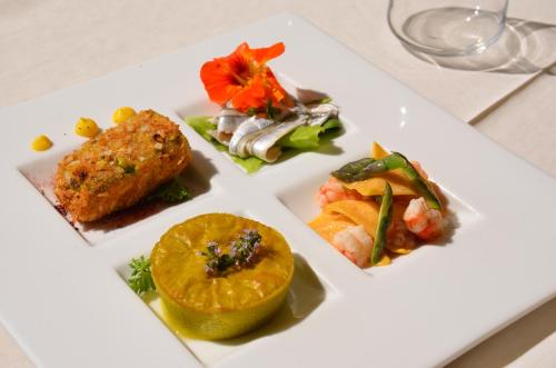 a white plate with different types of food on it at Villa Abbondanzi Resort in Faenza