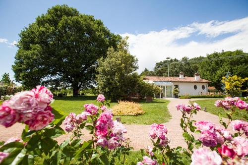a garden with pink flowers in front of a house at Villa Abbondanzi Resort in Faenza