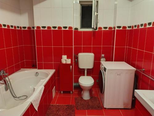 een rood betegelde badkamer met een toilet en een bad bij Class Apartments in Oradea