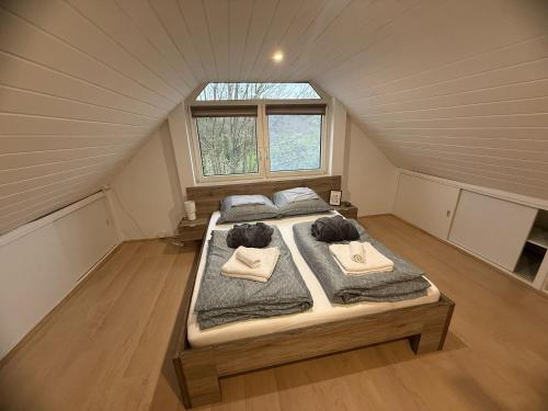 a bedroom with two beds in a attic at Offline vendégház in Orfű