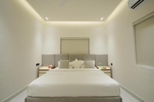a bedroom with a large bed in a white room at 6 BHK Serviced Apartment beside Kolencherry MOSC Hospital in Kadayirippu
