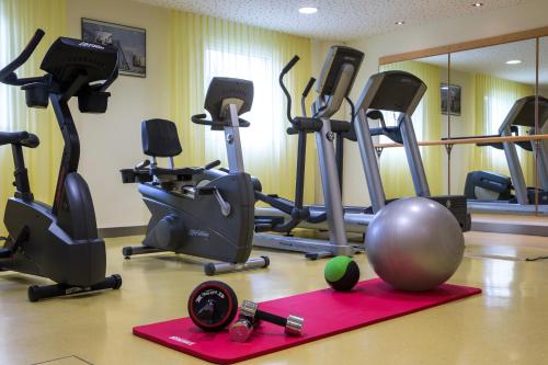 a gym with exercise bikes and a ball on the floor at Radisson Hotel Zurich Airport in Rümlang